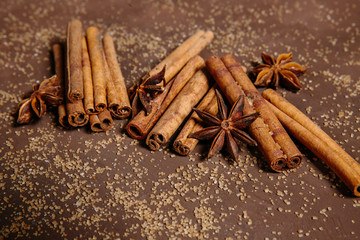 Cinnamon sticks and star anise on scattered brown sugar. The concept of baking, desserts, drinks, mulled wine