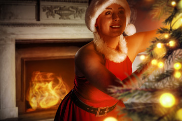 Slim young santa claus woman with christmas tree decoration and background of fireplace 