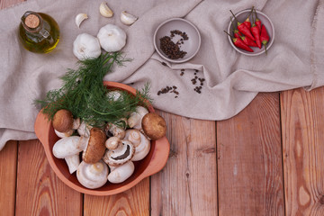 Champignon mushrooms, fresh greens, garlic and pepper in a ceramic plate. country style