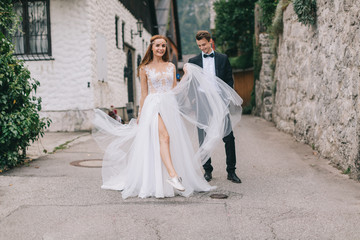 A fun wedding couple joking each other and walks in a fairy Austrian town, Hallstatt.