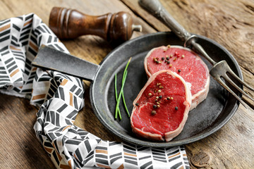 Tournedos de bœuf cru sur table rustique en bois