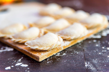 Raw dumplings or vareniki on wooden board