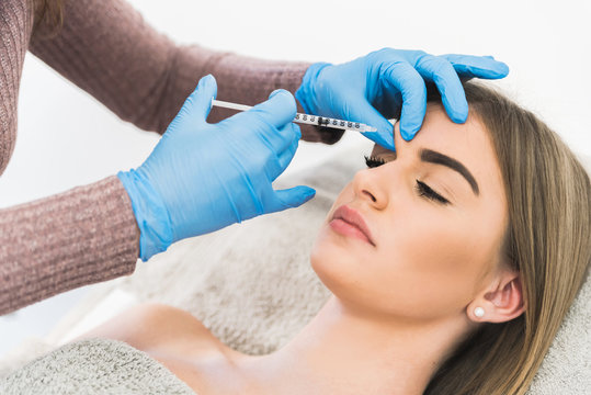 Woman receiving fillers on glabella