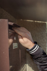 A thief trying to steal mail from the mailbox.