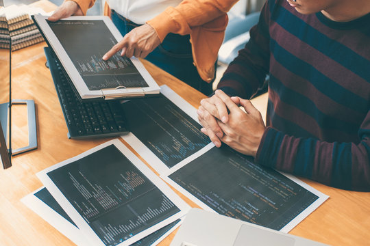 Professional Development programmer cooperating meeting and brainstorming and programming website working in a software and coding technology, writing codes and data code