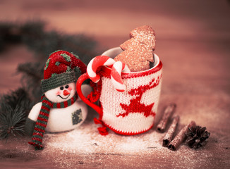 Mug Of Tea Or Coffee. Sweets And Spices. Christmas Decoration with snowman. Wooden Background.