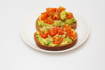 Avocado toast. Healthy toast with avocado mash and cherry tomatoes on a plate.