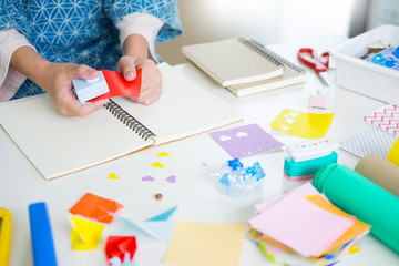 Woman's hand cut paper Making a scrap booking or other festive decorations DIY accessories arrangement.