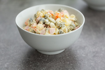 Russian salad in white bowl. National cuisine. Russian traditional salad Olivier for New Year party.