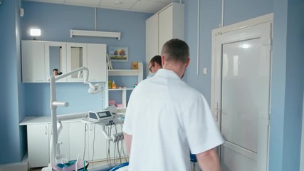 Doctor Welcoming the Patient at Visit and Inviting to the Dentist Chair Starting Consultation in the Stomatology Clinic