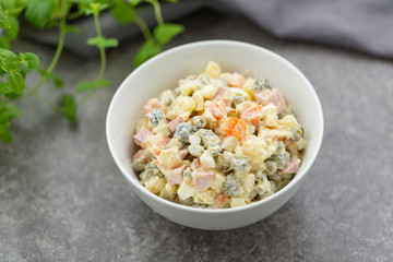 Russian salad in white bowl. National cuisine. Russian traditional salad Olivier for New Year party.