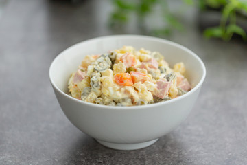 Russian salad in white bowl. National cuisine. Russian traditional salad Olivier for New Year party.