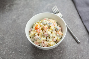 Russian salad in white bowl. National cuisine. Russian traditional salad Olivier for New Year party.