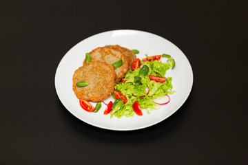 Potato pancakes with fresh mix of salad on a plate close-up.