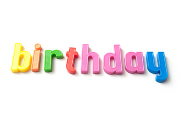 closeup of colorful plastic letters on white background - Birthday
