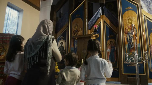 Family praying in the Orthodox Church.