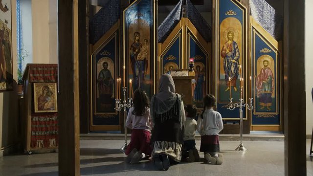 Family praying in the Orthodox Church.