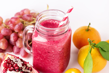 Fototapeta na wymiar Healthy Detox Smoothies on a White Background With Fruits Citrus Grape Pomegranate Glass Jar of Tasty Smoothie Horizontal