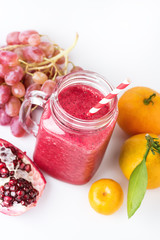 Healthy Detox Smoothies on a White Background With Fruits Citrus Grape Pomegranate Glass Jar of Tasty Smoothie Above