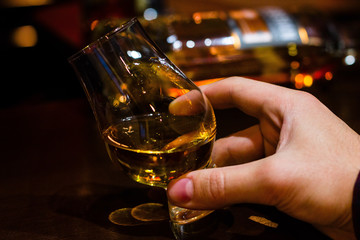 hand holding a glass of whiskey selective focus