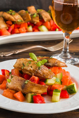 Tilapia fish fillet marinated in ginger and garlic sauce and roasted with olive oil. Fresh vegetable salad and whitefish on white plate