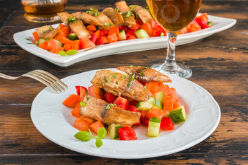 Tilapia fish fillet marinated in ginger and garlic sauce and roasted with olive oil. Fresh vegetable salad and white fish on white plate