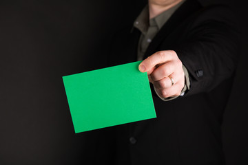 Businessman Holding a Green Card, Empty, Copy Space, Gradient Black background