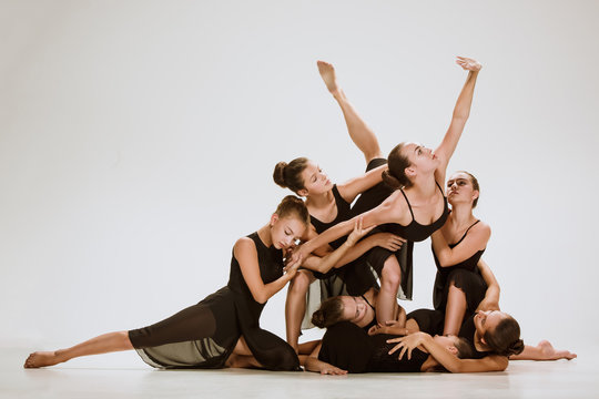 The group of modern ballet dancers dancing on gray studio background - Powered by Adobe