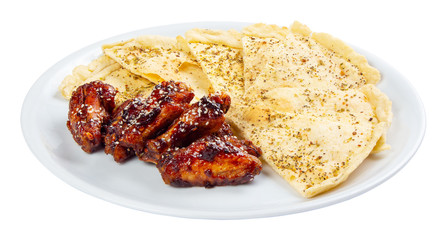 beer snack on the white plate. grilled chicken wings with italian pita bread chips