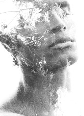Double exposure in black and white of a young sexy man’s portrait blended with branches of a tropical tree, showing the perfect beauty of nature's creation