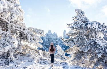 A girl on the background of a snow-covered forest and a mountain peak Ai-Petri.