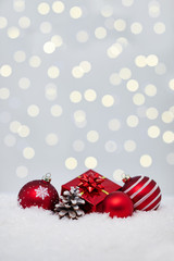 Christmas red balls on snow with bokeh lights