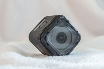 Small square high definition sport camera isolated on a white fur background