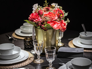 Table decoration with red flowers and kitchenware