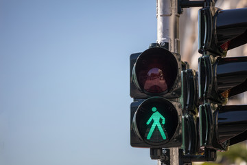 Green traffic lights for pedestrians, blue sky background