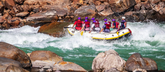 Young persons rafting on the river Ganges in Rishikesh, extreme and fun sport at tourist attraction