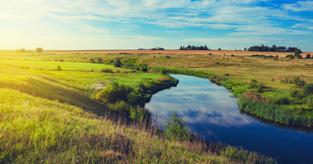 Sunny summer landscape with fields,green pastures,river and beautiful woods.