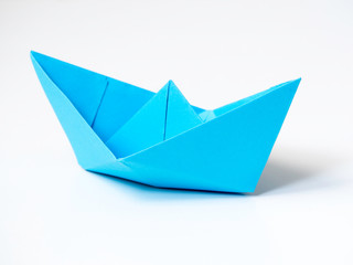 Single Blue paper boat on white