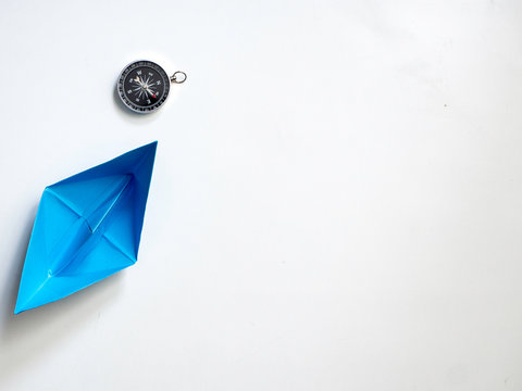 Blue paper boat with compass