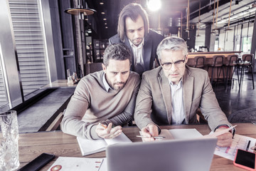 Fototapeta premium Delighted males discussing business idea during meeting