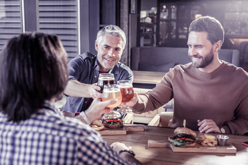 Pleased bearded man feeling happiness with friends
