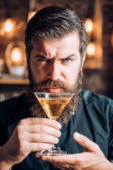 Barman with martini or liquor. Bearded man wearing suit and drinking alcohol. Drink and celebration party concept. Degustation and tasting.