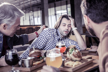 Drunk young man leaning on his arm