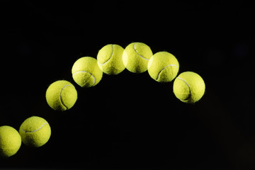 Movement or bounce of tennis ball isolated on black background.