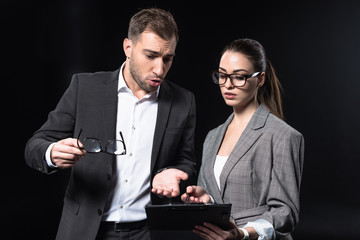 young business people with clipboard having conversation isolated on black