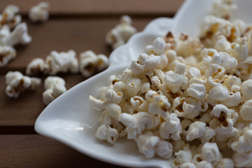 popcorn in white plate on wooden background