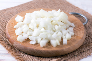 Sliced onion on a cutting wooden board