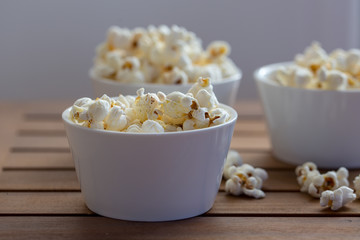 popcorn  on white plate on wooden background