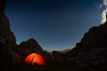 starry night sky high in the mountains and a tent