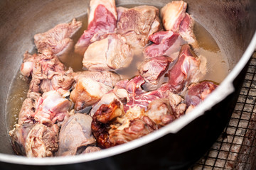 Lamb pieces stew in a cauldron